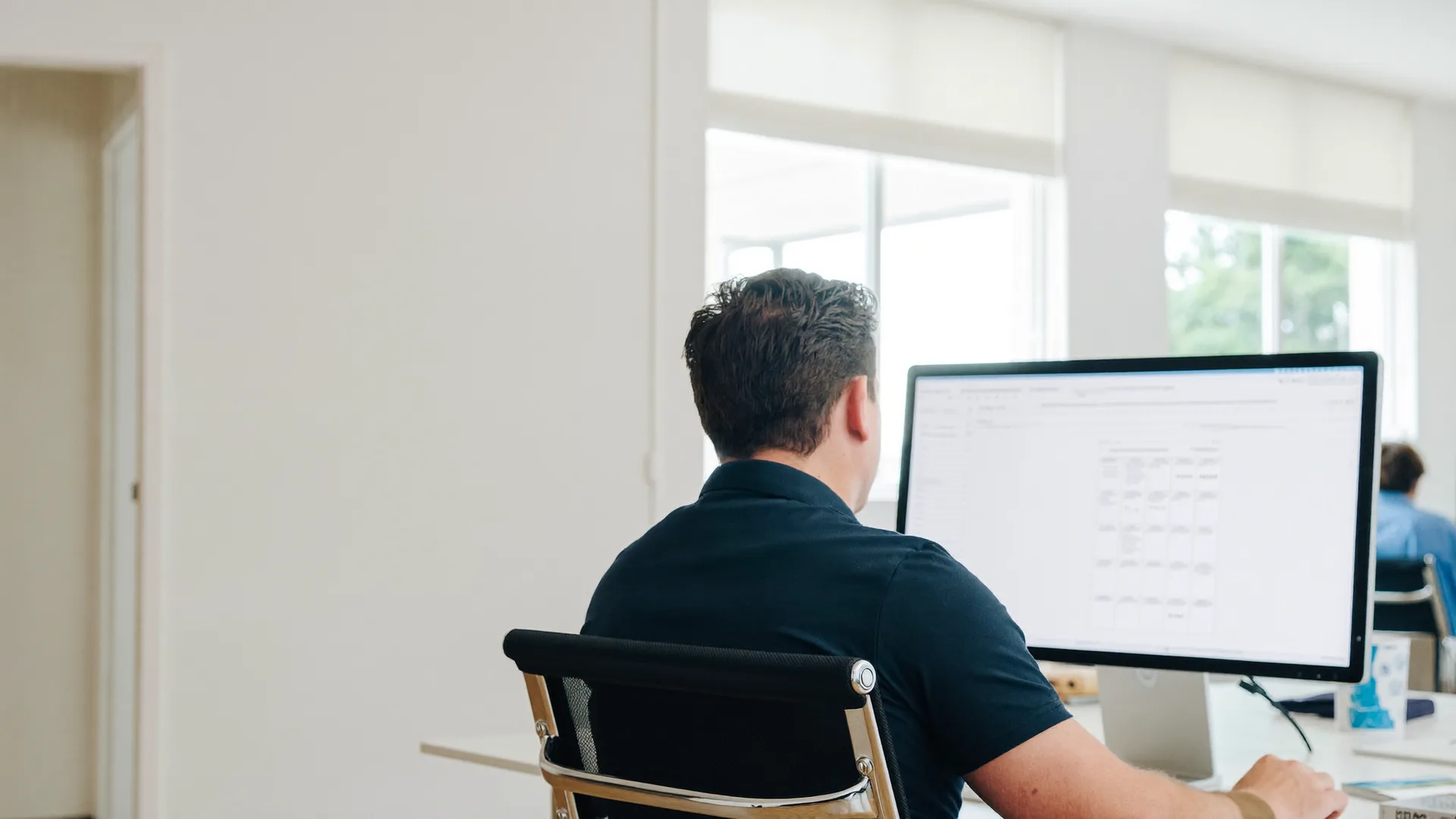 Jordy van Boutio werkt aan een webapplicatie op een groot scherm